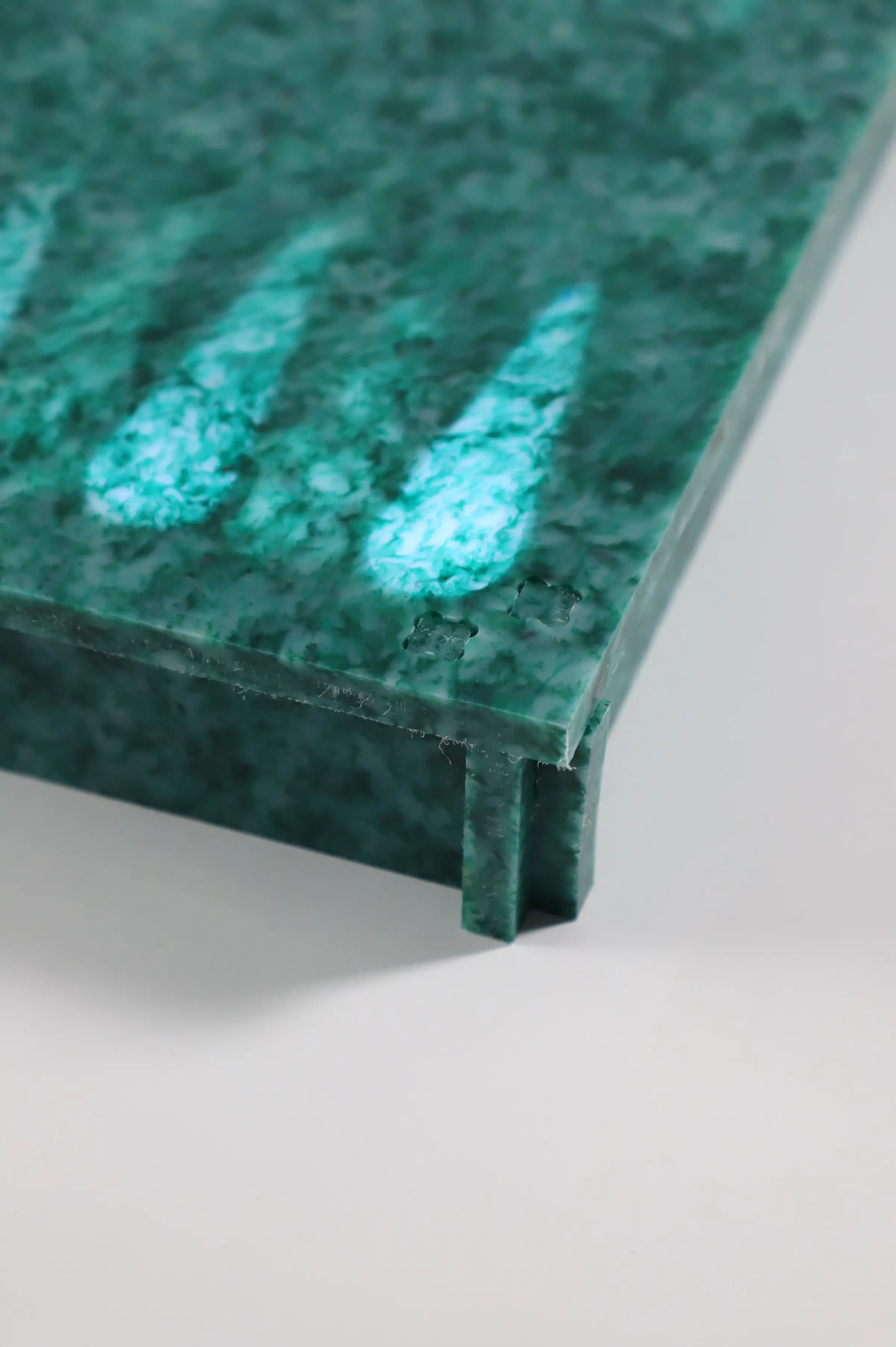 Close detail of the finished board - the recycled-plastic surface and its raised edge